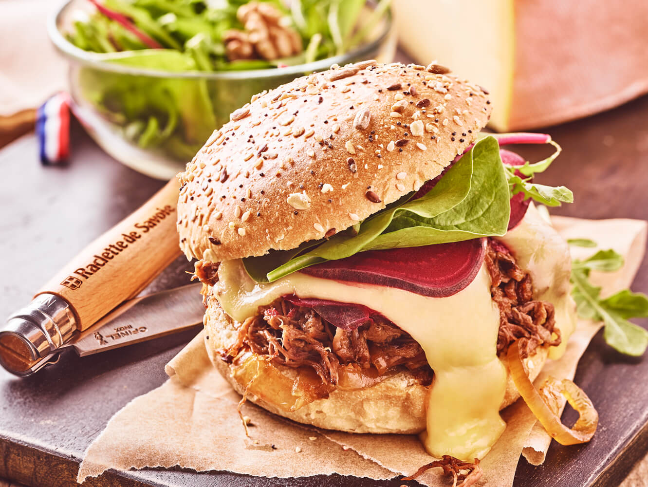 Burger à l'effiloché de boeuf, oignons confits et Raclette de Savoie 