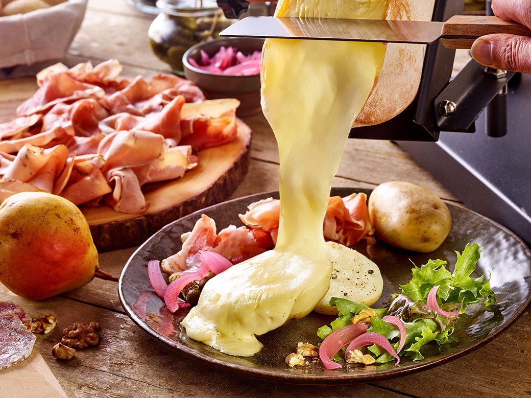 Raclette fondante sur des pommes de terres