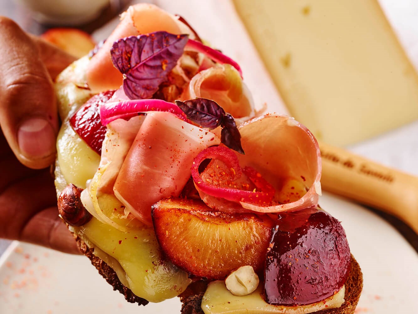 tranche de pain avec de la raclette de Savoie, prune et noisette